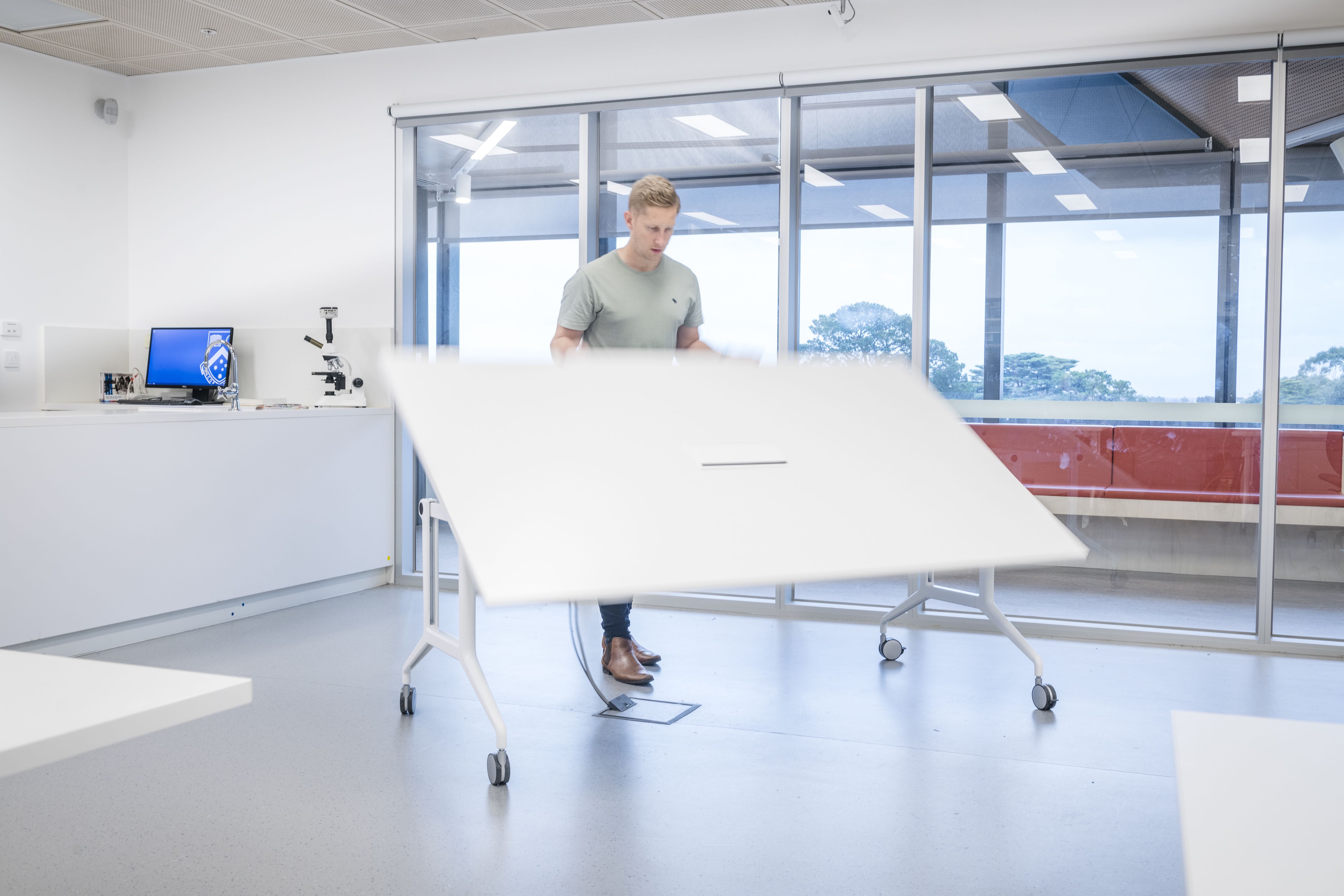 furniture, table, desk, adult, male, man, person, monitor, screen, shoe